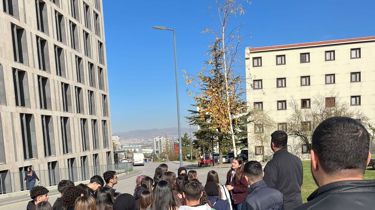 Öğrenciler üniversite kampüsünde binaların önünde