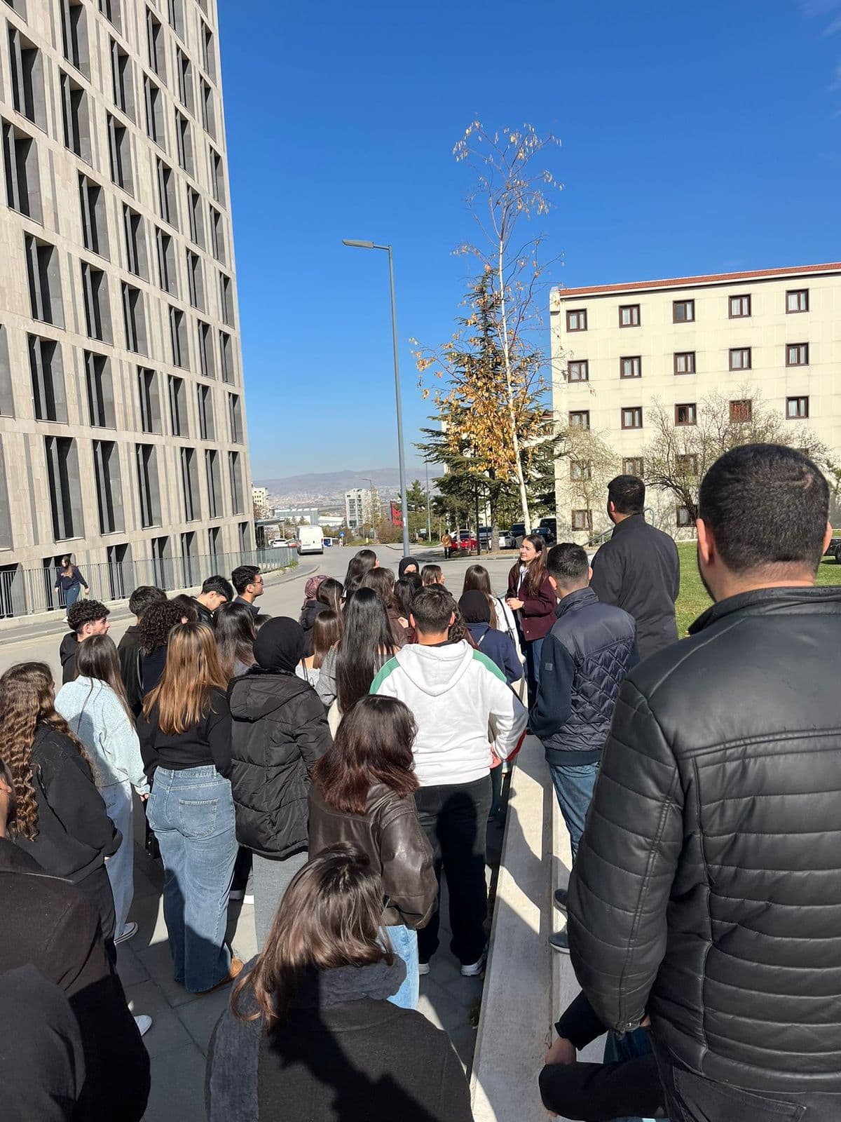 Genç Kalem öğrencileri bir üniversite kampüsünde grup hâlinde yürürken