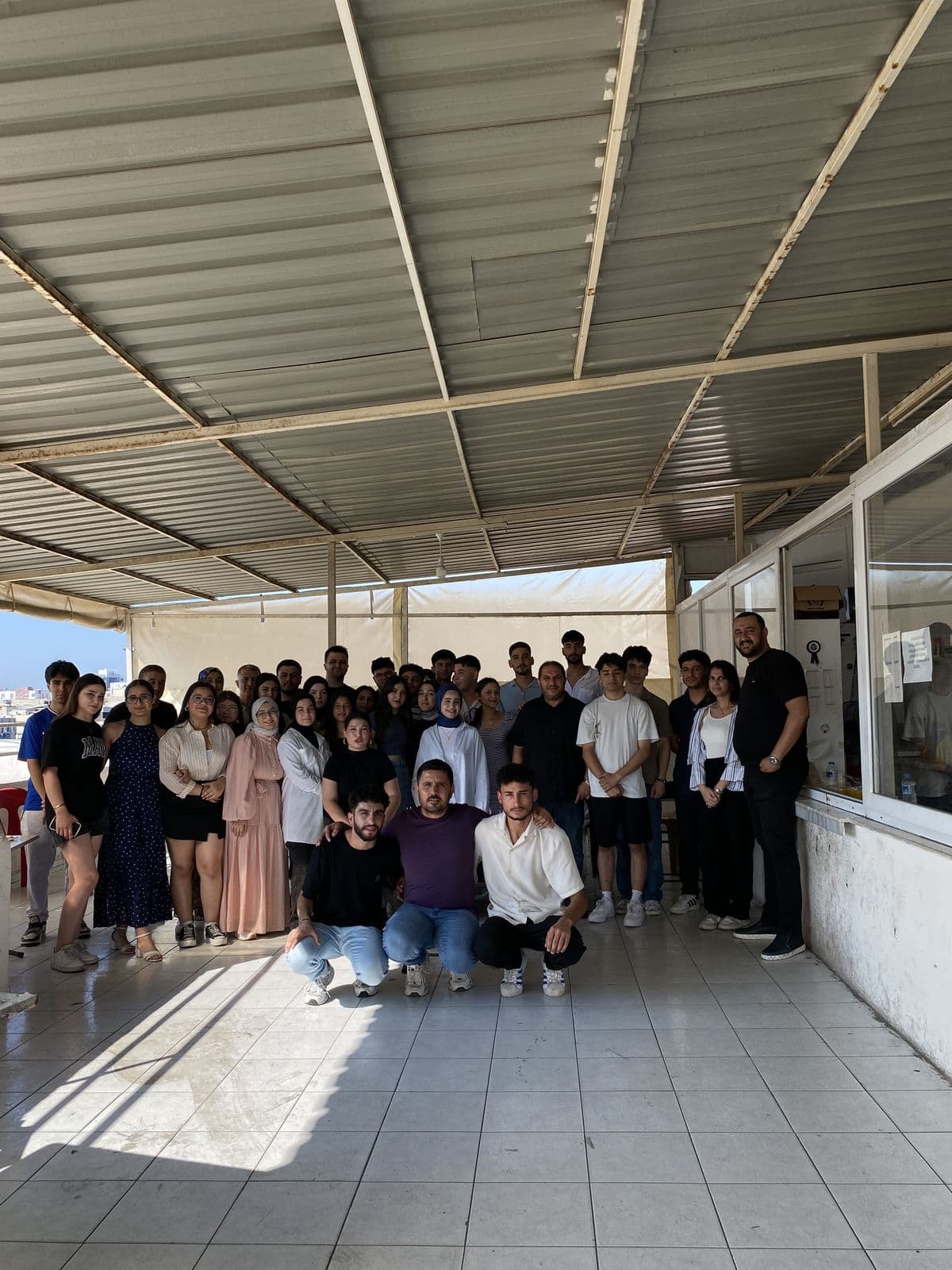 Öğrenciler ve öğretmenlerin kurum terasında çekilmiş grup fotoğrafı